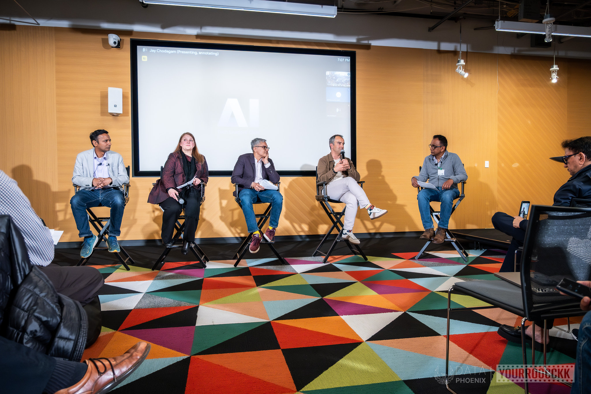 Five panelists on stage in front of a screen with an AI logo, one speaking, at AI Tech Leader's Club Q1 2026