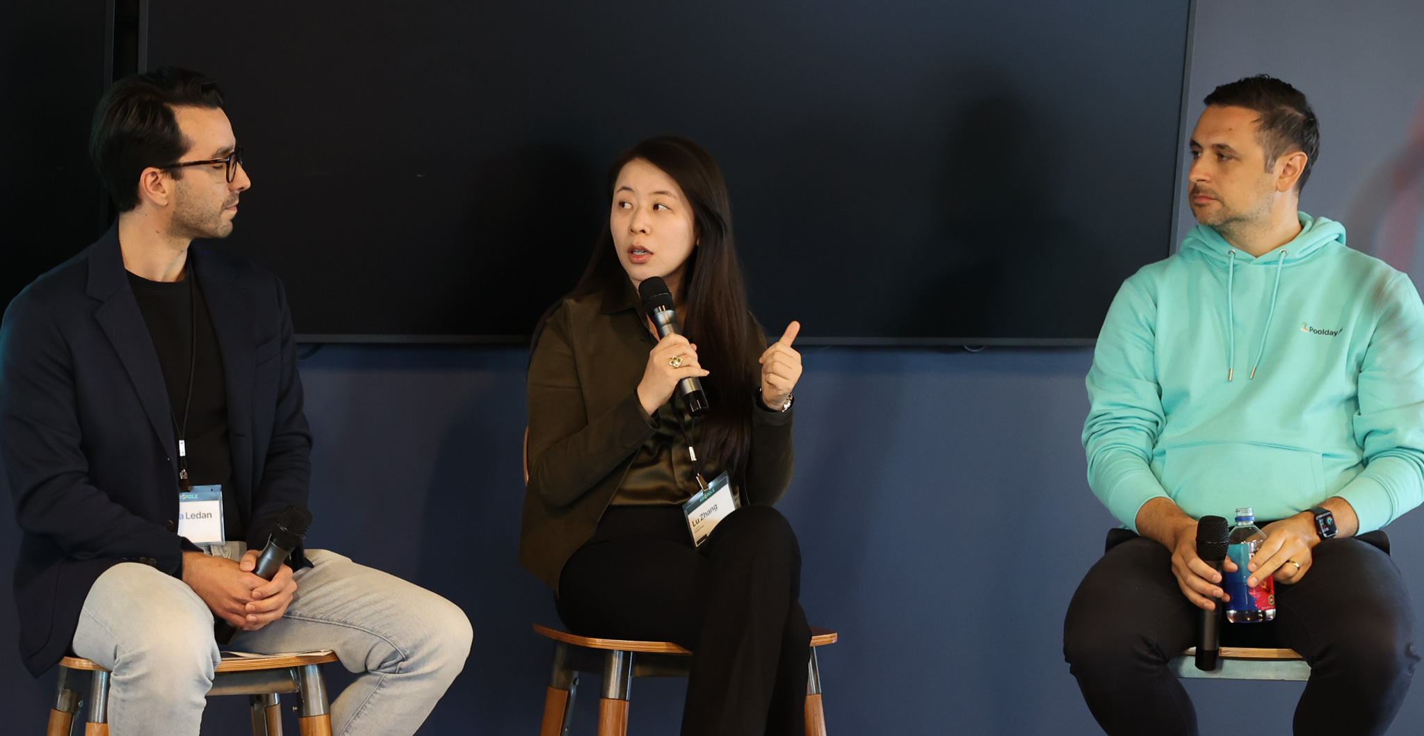 Three panelists on stools during the VC panel at Raisable Pitch Night, one speaking into a microphone