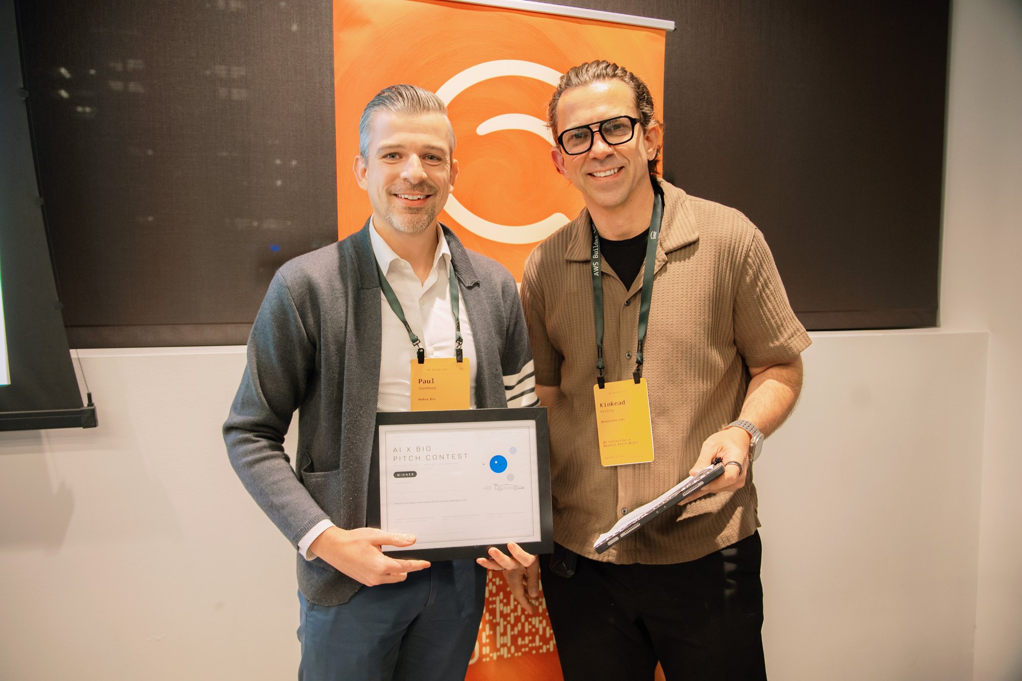 Paul Donohoue of Umbra Bio holding the winner certificate beside Kinkead Reiling at AI x Bio Pitch Contest.