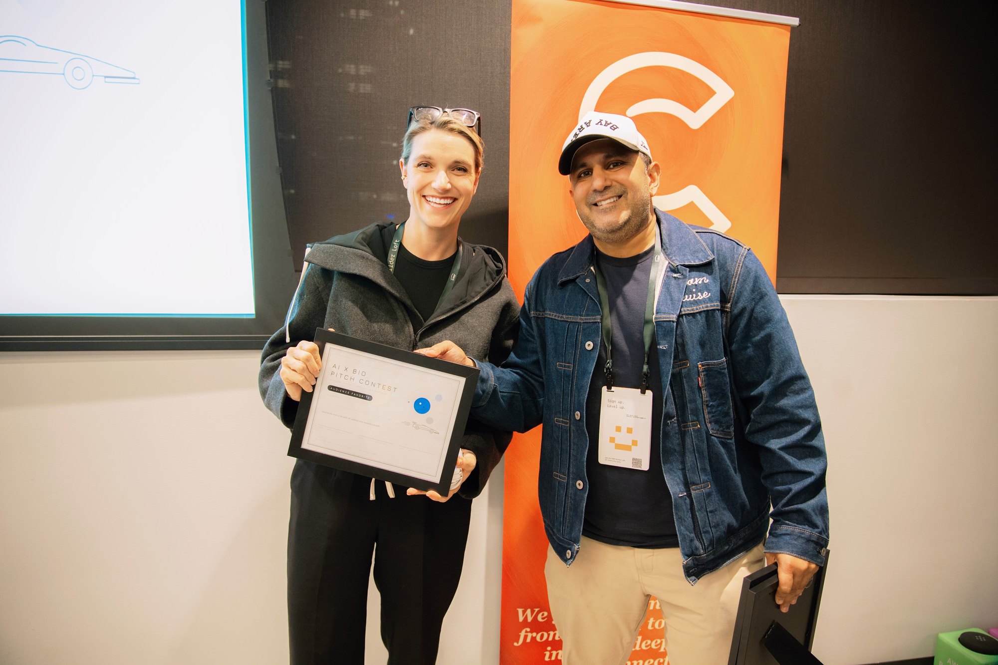 Ambitious Bio representative holding the Audience Favorite certificate at AI x Bio Pitch Contest.